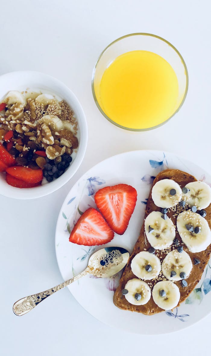 Nutritious breakfast with banana toast, fruit bowl, and orange juice, perfect for a healthy start.